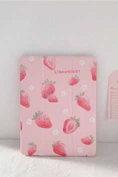 a pink notebook with strawberries on it