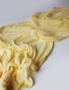 two pieces of yellow fabric on a white surface