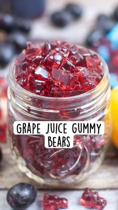 grape juice gummy bears in a glass jar next to lemons and blueberries