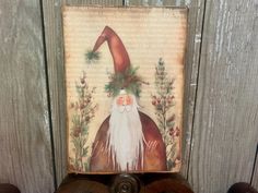 a painting of a gnome with long white hair and beard on top of a wooden shelf