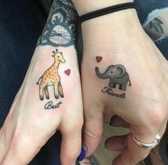 two people with matching tattoos on their hands holding each other's hand and one has an elephant, giraffe, and heart