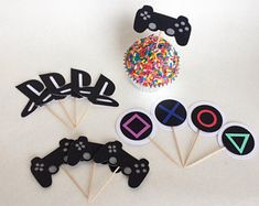 some cupcake toppers are sitting on a table next to an object that looks like a video game controller