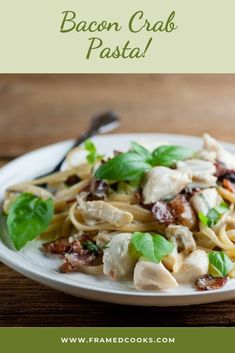 a white plate topped with pasta covered in chicken and spinach next to a fork