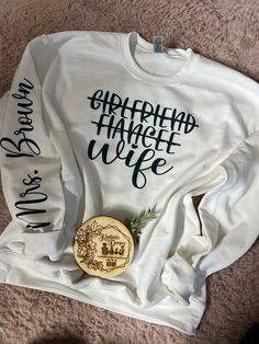 Girlfriend Fiancé Wife sweater with your customized last name to be on right sleeve Personalized White Sweater For Winter, White Relaxed Fit Sweater With Custom Print, White Sweater With Name Print For Fall, Fall Sweater With Name Print And Crew Neck, White Fall Sweater With Name Print, Fall Crew Neck Sweater With Name Print, White Long Sleeve Sweater With Name Print, Wife Sweater, Sweat Couple