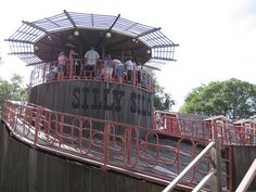 several people are standing on the top of a structure with stairs and railings that lead up to it