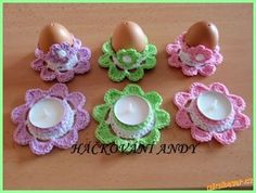 an assortment of crocheted eggs and candles on a table