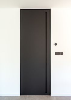 a black door is open in an empty room