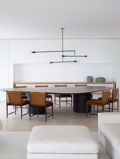 a dining room table with chairs and a bench in front of it, next to a couch