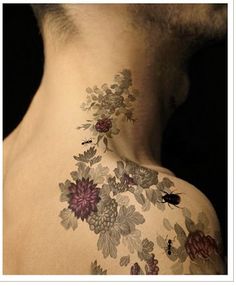 the back of a man's neck with flowers on it