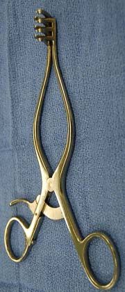 a pair of gold colored scissors on a blue towel with the handles bent down to be used for cutting hair