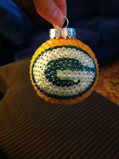 someone is holding an ornament made out of beads