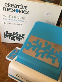 a blue and white box sitting on top of a wooden table next to a book