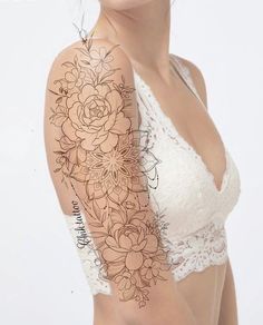 a woman's arm with flowers on it and a lace bra top over her