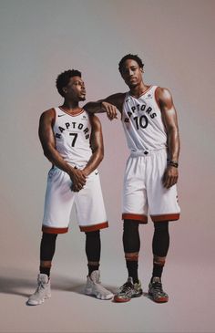 two basketball players standing next to each other in white and black uniforms with numbers on them