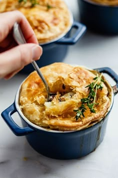 a person is spooning some food out of a casserole dish