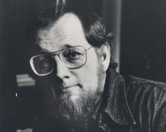 an old black and white photo of a man with glasses looking at something in the distance