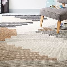 a living room with a chair and rug on the floor