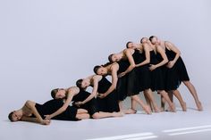 a group of dancers pose in front of a white background