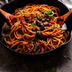 a skillet filled with spaghetti and olives