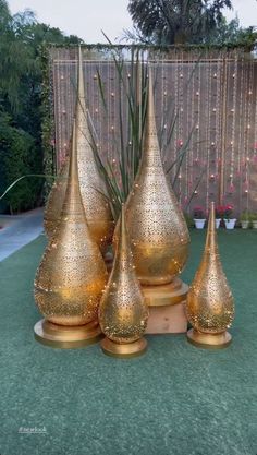 three gold vases sitting on top of a table