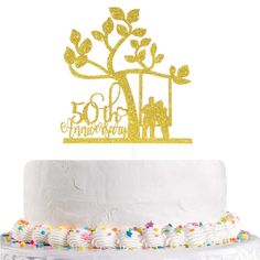 a white cake topped with a gold 50th birthday cake topper