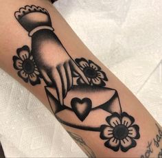 a black and white photo of a woman's arm with tattoos on it