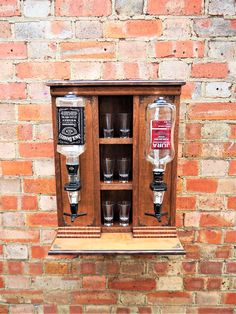 an old fashioned wooden cabinet with glasses in it on the side of a brick wall