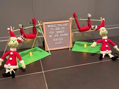 the elfs are doing yoga on their own legs and feet in front of a sign