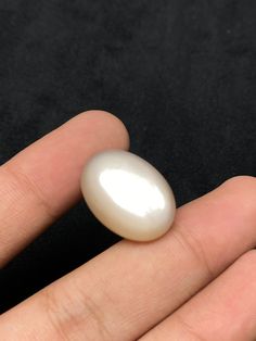 a person's hand holding a small white object