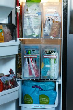 the refrigerator door is open and filled with plastic bags, containers, and other items