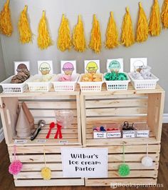 a wooden crate filled with yarn and crochet hooks next to tassels