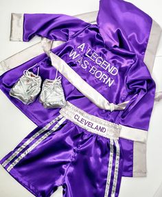 the purple and silver outfit is next to two boxing gloves