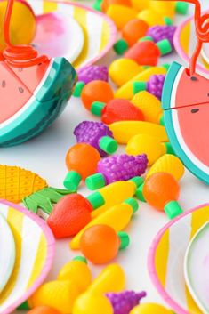 a table topped with lots of colorful plates and bowls filled with fruit on top of each other