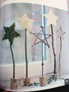 an open book with trees and stars on it's cover, in front of a window