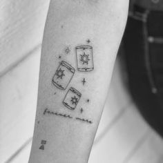 a person with a tattoo on their arm that has two mugs and stars in it