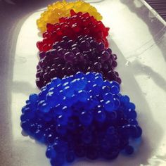 there are many different colored beads on the tray