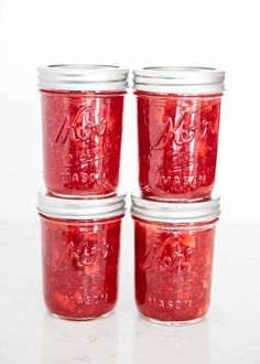 three jars filled with red liquid sitting on top of a table