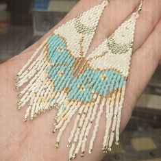 a person's hand holding a beaded piece of jewelry