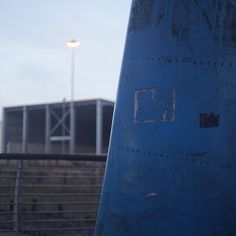 an airplane sitting on the ground next to some stairs and a light pole in the background