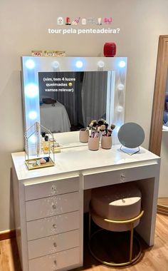 a white vanity with lights on it and a stool