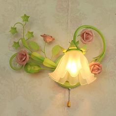 a wall mounted light with flowers on it