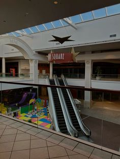 an escalator in a shopping mall with colorful slides