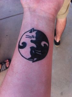 a person with a cat tattoo on their wrist