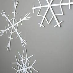 white snowflakes hanging from the ceiling on a gray background with space for text