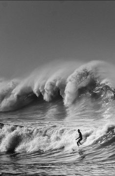 a man riding a wave on top of a surfboard