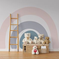 teddy bears sitting on top of a dresser in front of a wall with a rainbow design