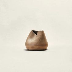 a wooden vase sitting on top of a white surface