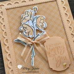 a close up of a card with a tag on it and a flower in the middle