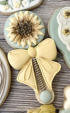 decorated cookies with sunflowers and other decorations on top of a wooden table next to cookie cutters