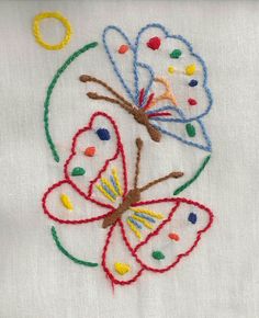 the embroidered butterfly has been stitched on to a piece of white fabric with multicolored threads